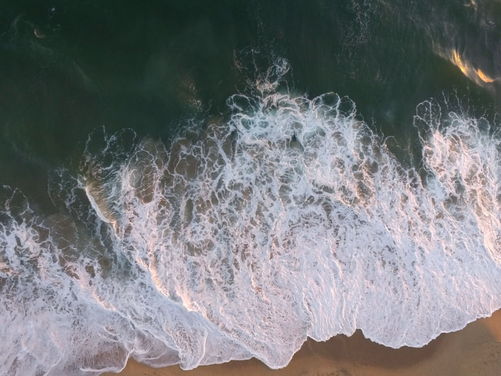 Aerial view of ocean foam and green water off the Orange County coast