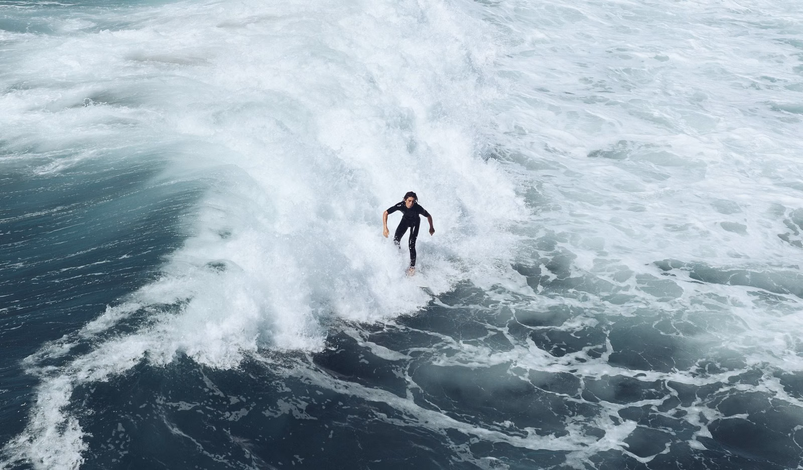 A surfer riding through whitewater off Huntington Beach, California